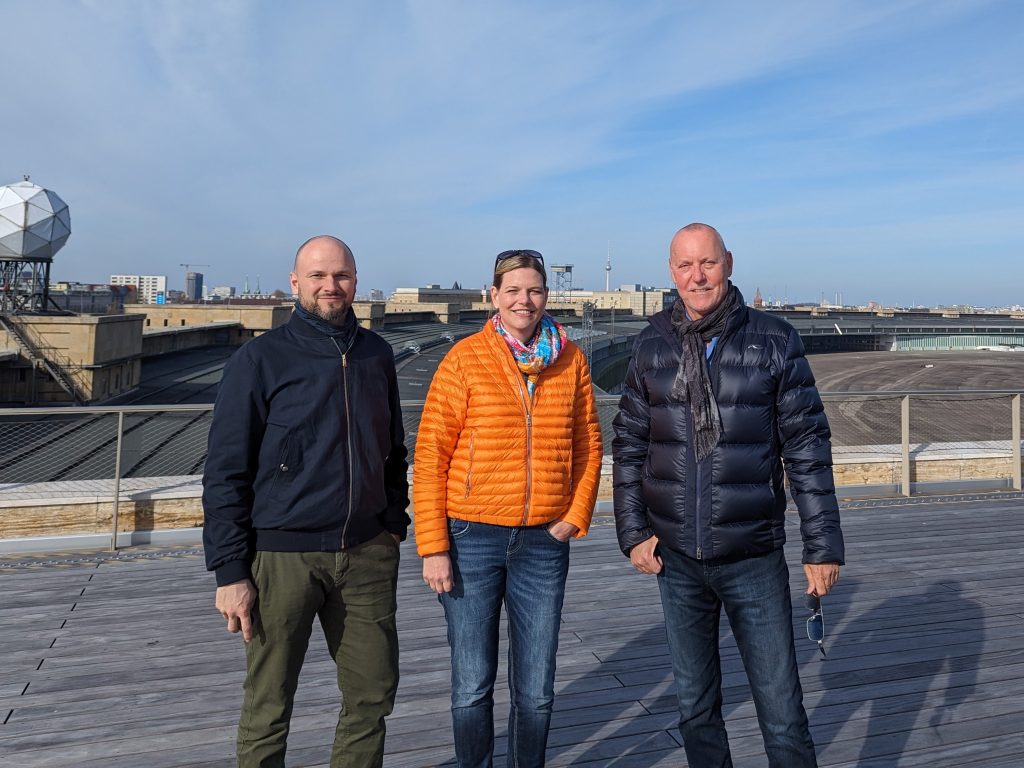 Drei Personen stehen auf einer Baustelle am Flughafen Tempelhof