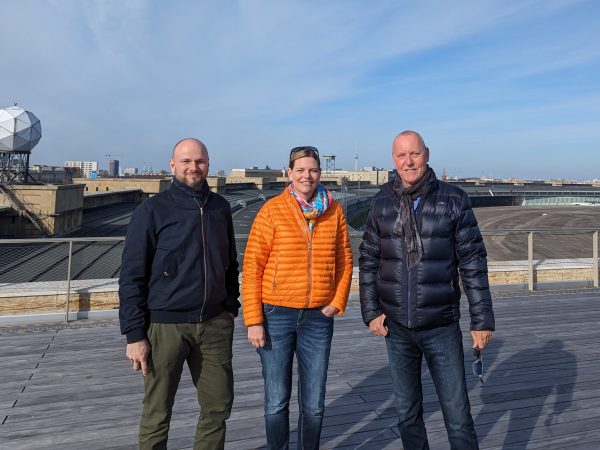 Drei Personen stehen auf einer Baustelle am Flughafen Tempelhof