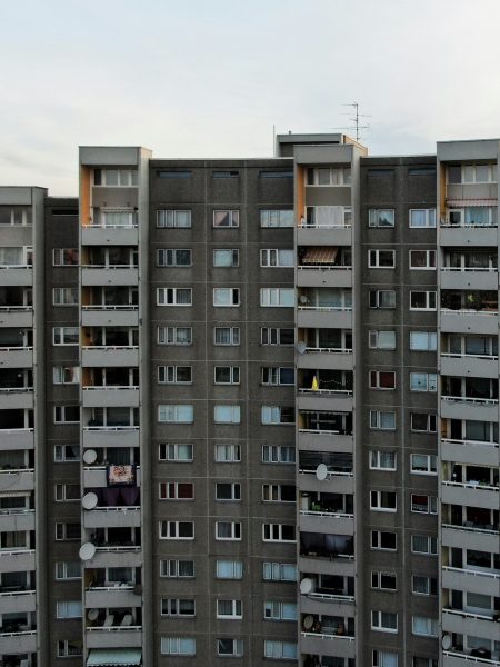 Ein über zehnstöckiger grauer Plattenbau mit Balkonen